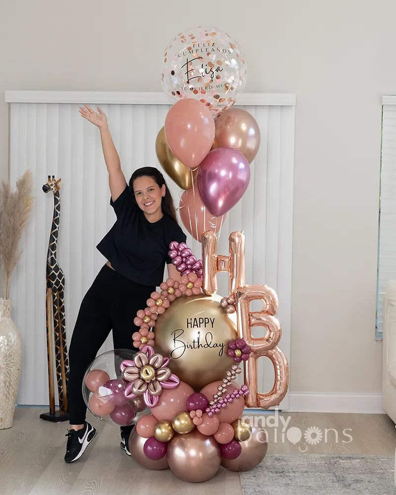 Birthday balloon setup with helium balloons, fresh flowers, and HBD letter balloons