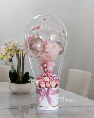 Hot air balloon-inspired flower arrangement featuring a bubble balloon and fresh cut roses, perfect for gifting or special occasions