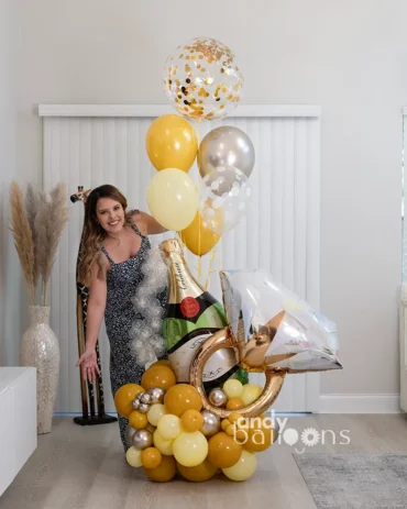 Balloon arrangement for an engagement party featuring a champagne bottle balloon and a giant ring balloon, perfect for celebrating the big ‘Yes!’