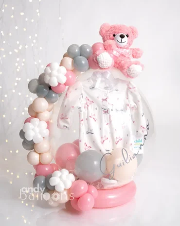 Personalized baby girl stuffed balloon gift with pink accents, featuring a plush bear and onesie inside.