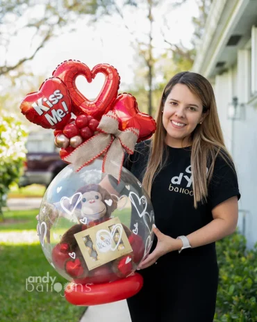A stuffed balloon gift featuring a plush monkey and Ferrero Rocher chocolates with red and gold heart balloons on top for Valentine's Day delivery.