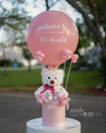 Personalized pink hot air balloon gift with a white teddy bear in a pink box for a baby girl.