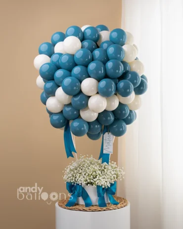 Personalized blue and white hot air balloon arrangement for a baby boy welcome with fresh baby's breath and blue satin bows.