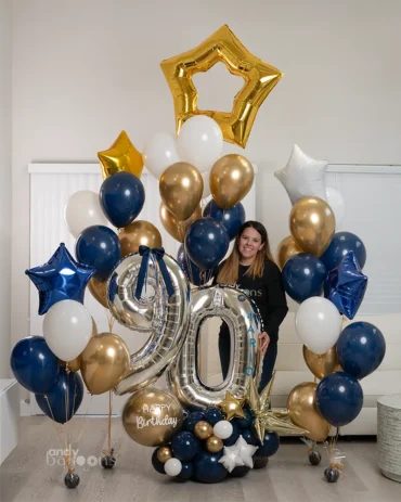 Large navy, gold, and white milestone balloon display for a 90th birthday, featuring silver number balloons and gold star accents.